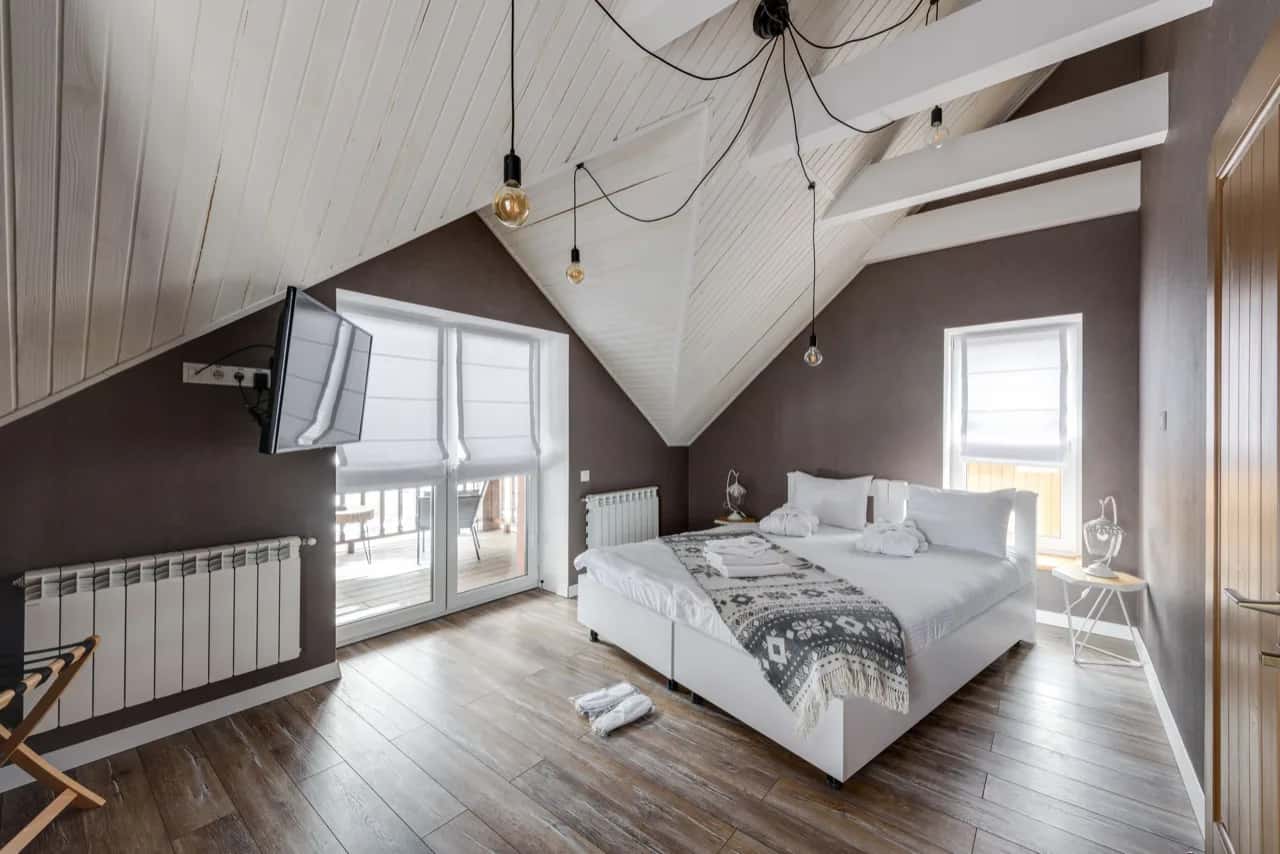 Styled loft bedroom with pendant lights and a made bed, ready for short-term guests - short-term rental ADU builders, Ontario, Canada