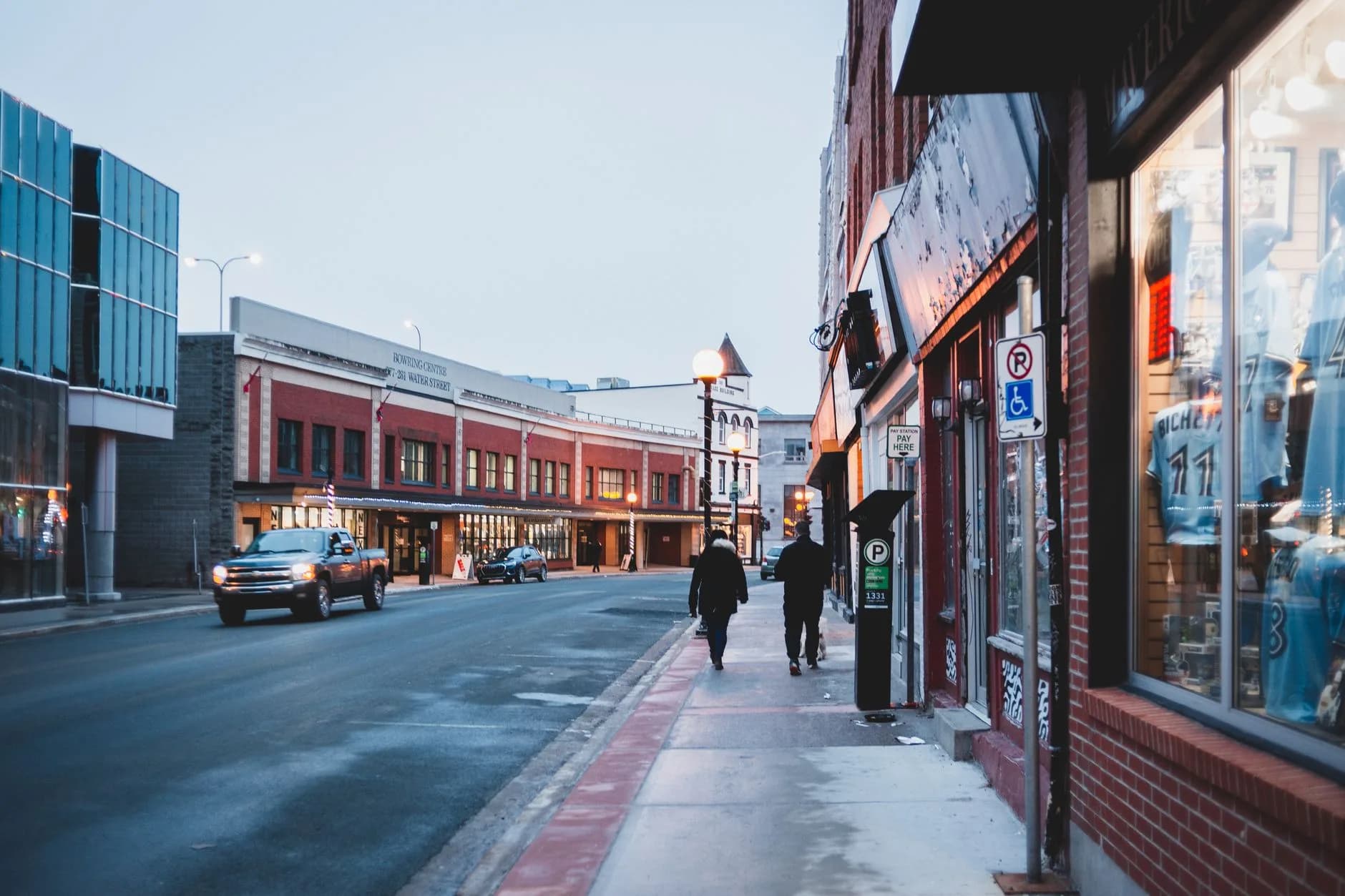 A town street with brick buildings, a modern glass building and pedestrians - ADU builders serving East Gwillimbury, Ontario, Canada
