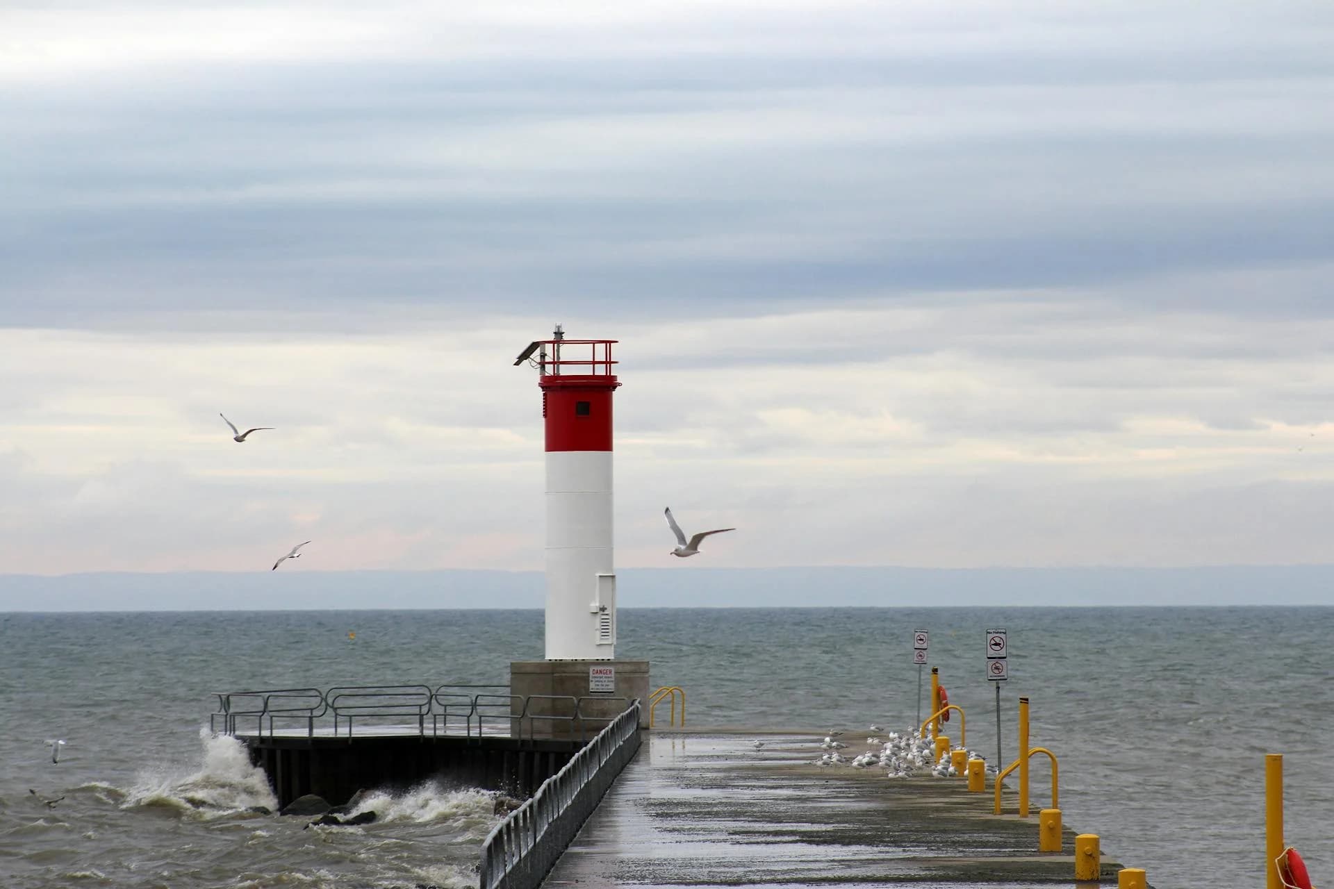 The Oakville lighthouse on its pier above choppy water - ADU builders serving Oakville, Ontario, Canada