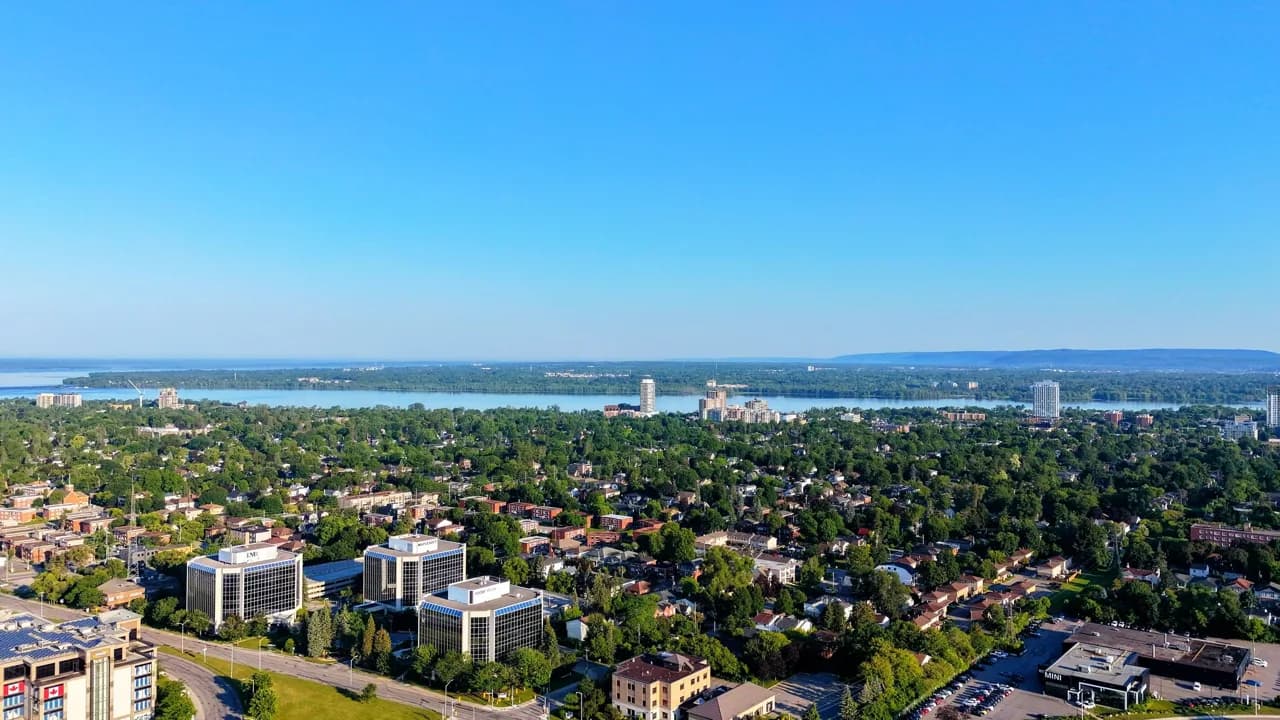 Summer aerial view of a leafy Richmond Hill residential neighbourhood with a lake on the horizon - ADU builders serving Richmond Hill, Ontario, Canada