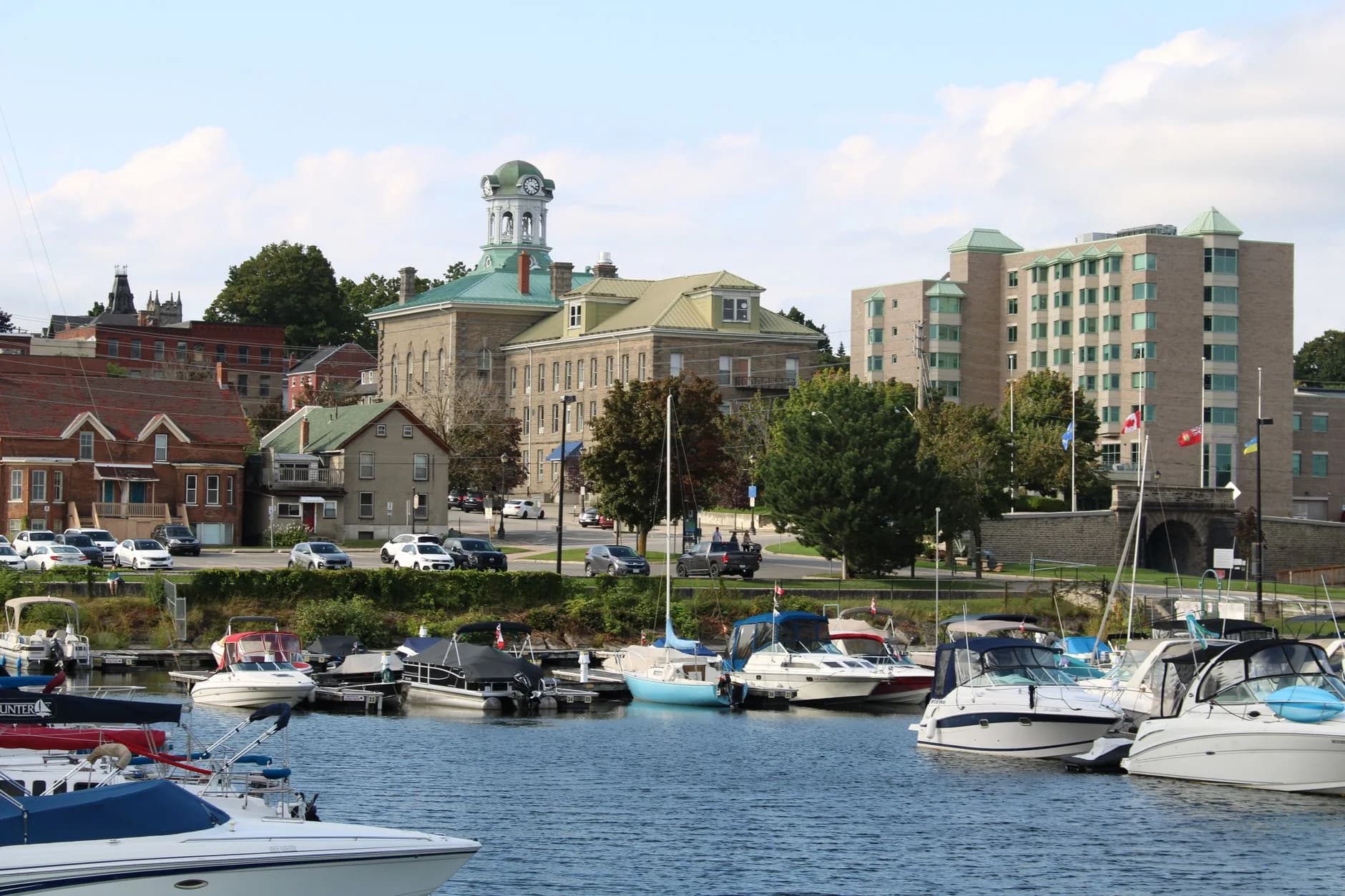 The Port Perry waterfront with docked boats and a clock-tower building behind - ADU builders serving Scugog, Ontario, Canada