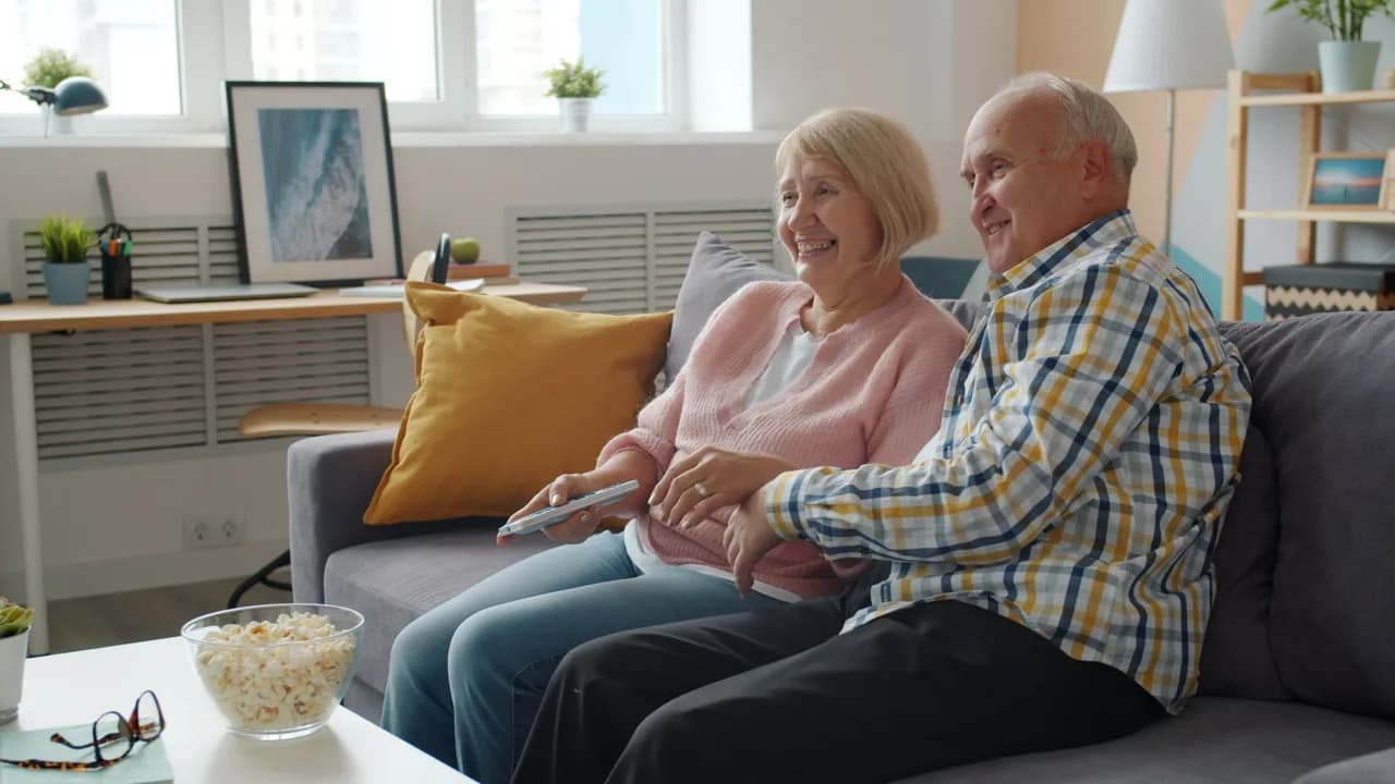 A senior couple relaxing together on a sofa in a bright living room - in-law suite builders, Ontario, Canada