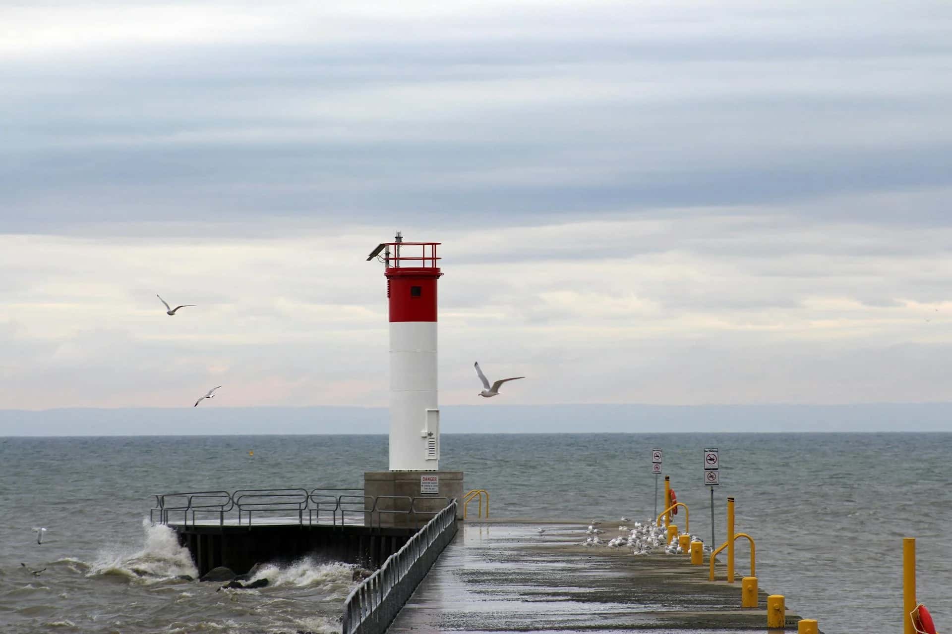 The Oakville lighthouse on its pier above choppy water - ADU builders serving Oakville, Ontario, Canada