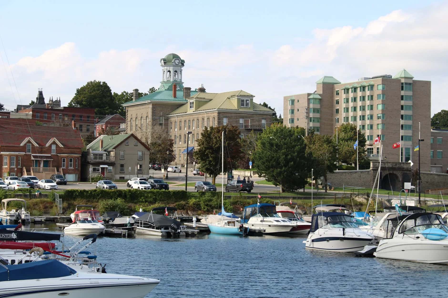 The Port Perry waterfront with docked boats and a clock-tower building behind - ADU builders serving Scugog, Ontario, Canada